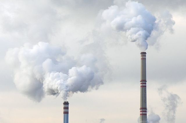 Smoke or condense water comes out of two chimneys of a factory