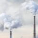Smoke or condense water comes out of two chimneys of a factory